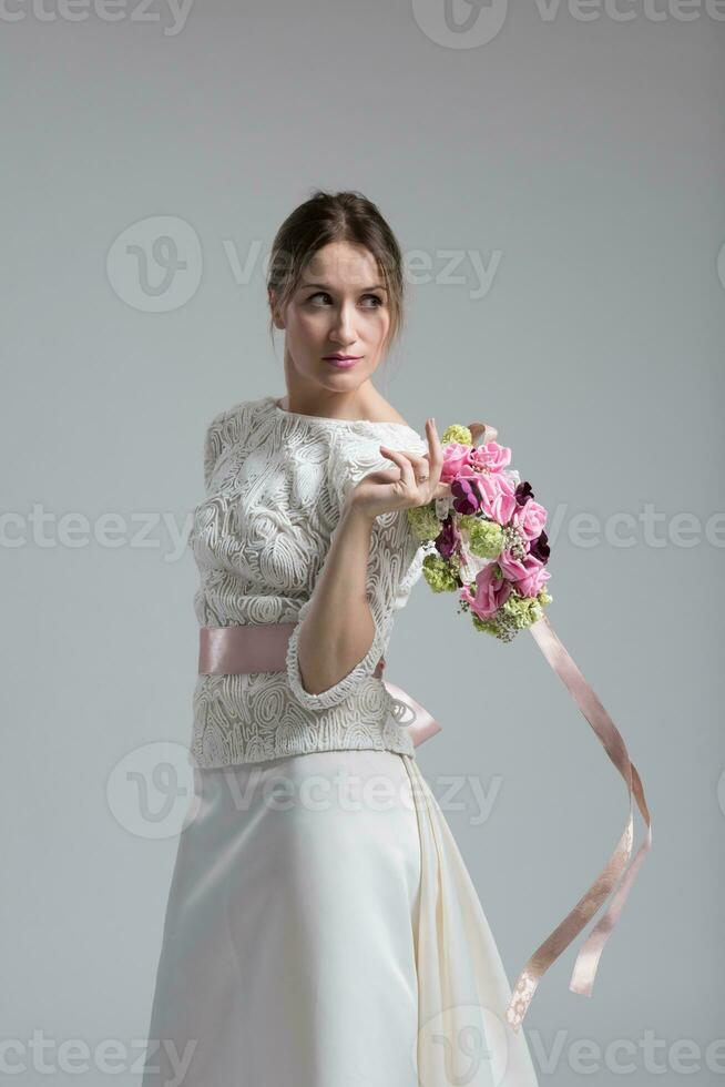 Braut mit einem Blumenstrauß isoliert auf weißem Hintergrund foto