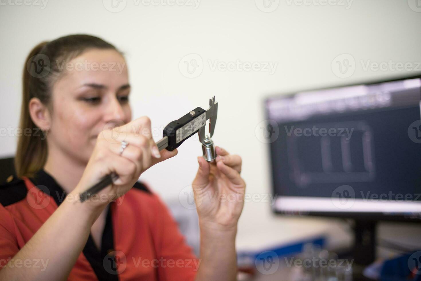 In der Schwerindustrie misst ein Wirtschaftsingenieur einer Fabrik mit einem Messschieber und entwirft auf einem PC ein 3D-Modell foto