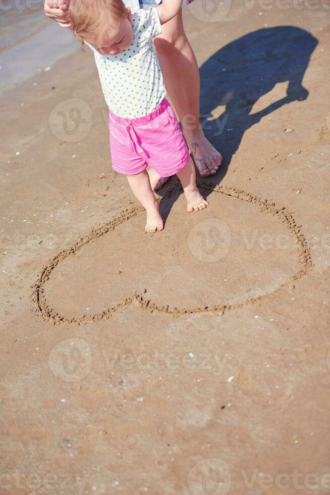 Mama und Baby am Strand haben Spaß foto