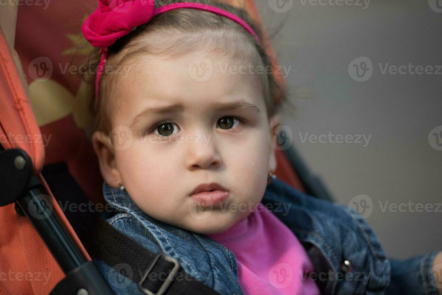 Babymädchen, das im Kinderwagen sitzt foto