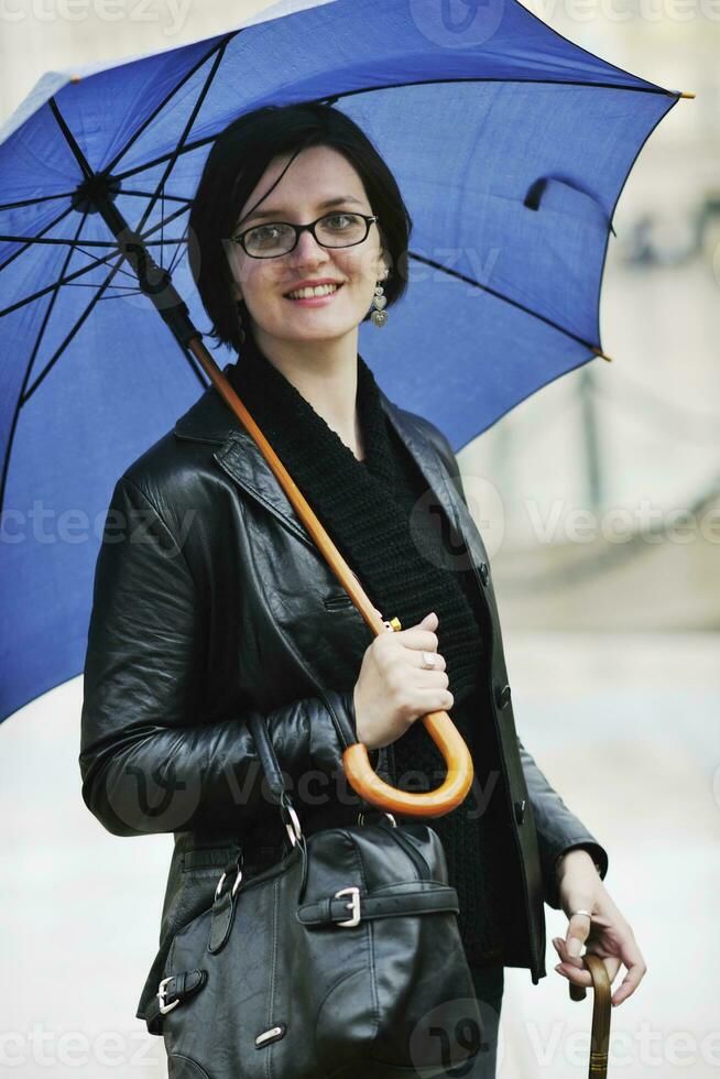 Frau auf der Straße mit Regenschirm foto