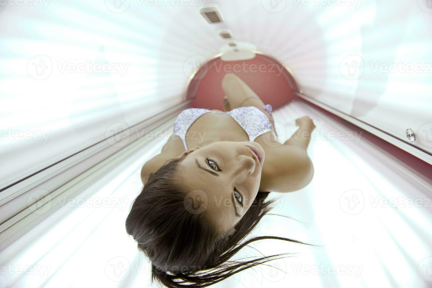 schöne junge Frau im Solarium bräunen foto