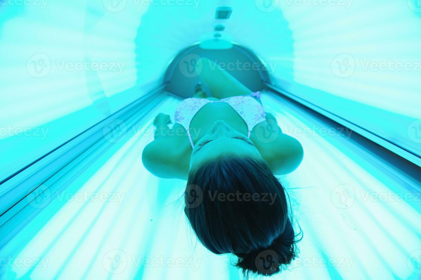 schöne junge Frau im Solarium bräunen foto