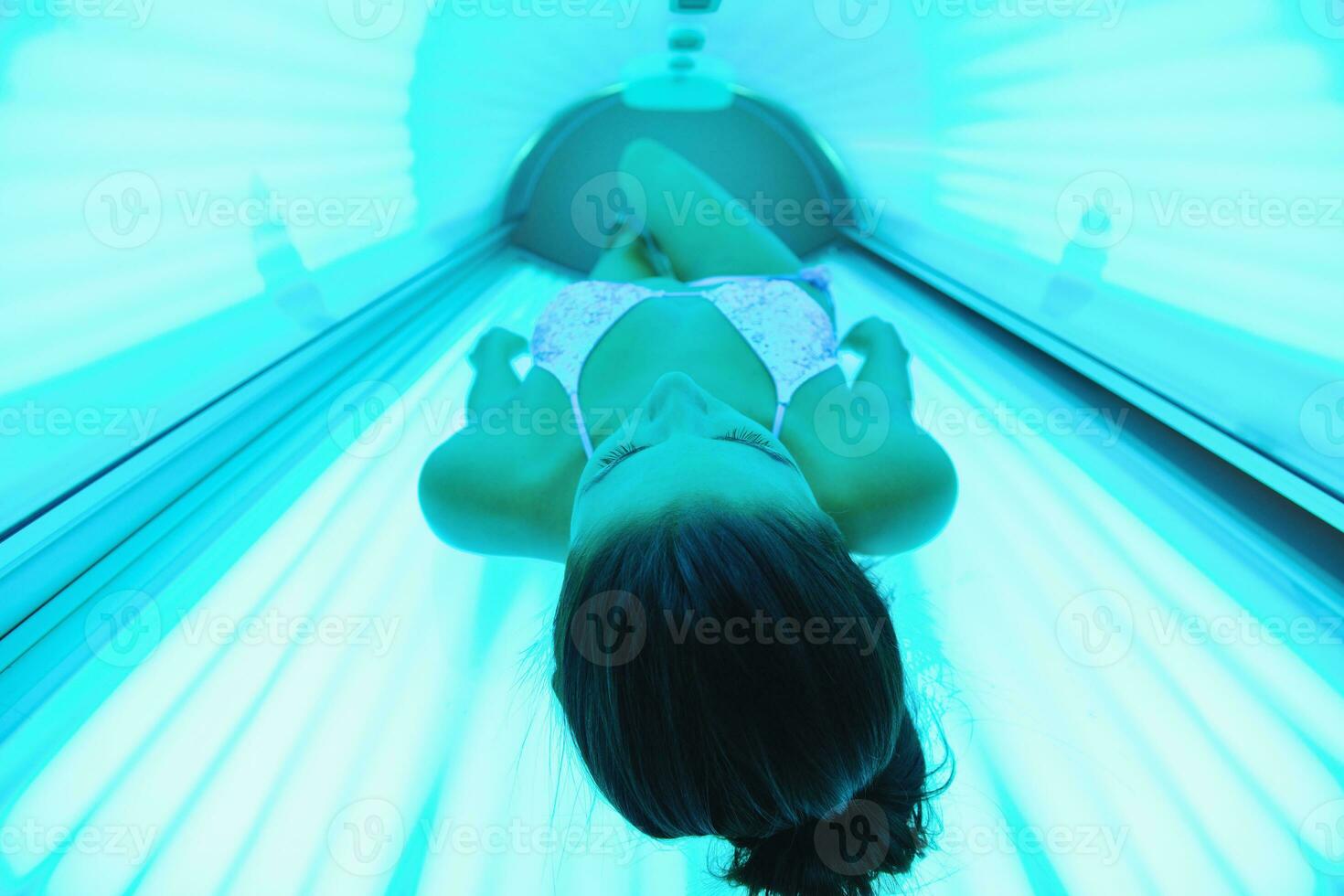 schöne junge Frau im Solarium bräunen foto