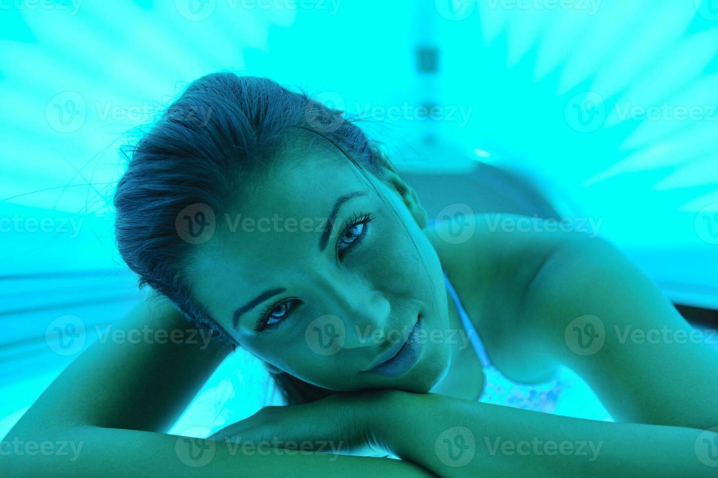 schöne junge Frau im Solarium bräunen foto