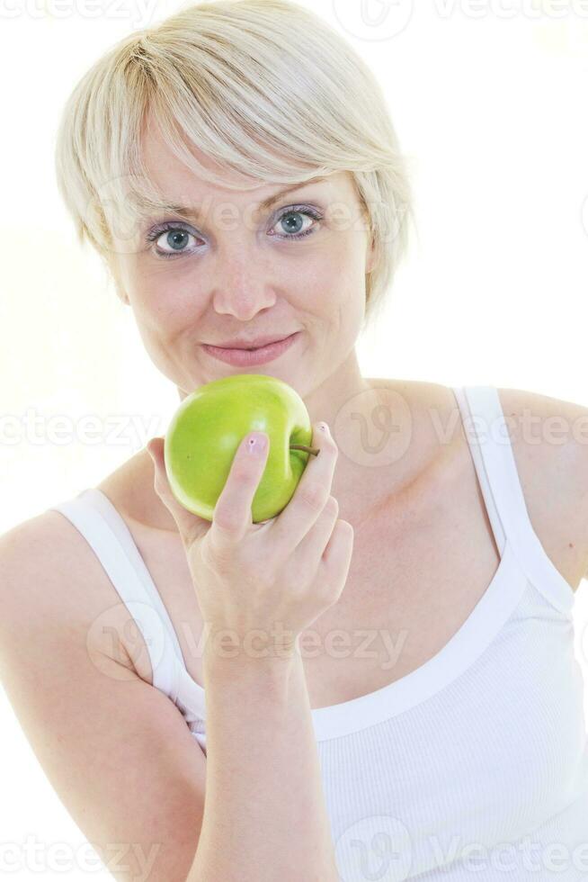 glückliche junge Frau isst grünen Apfel, isoliert auf weiss foto