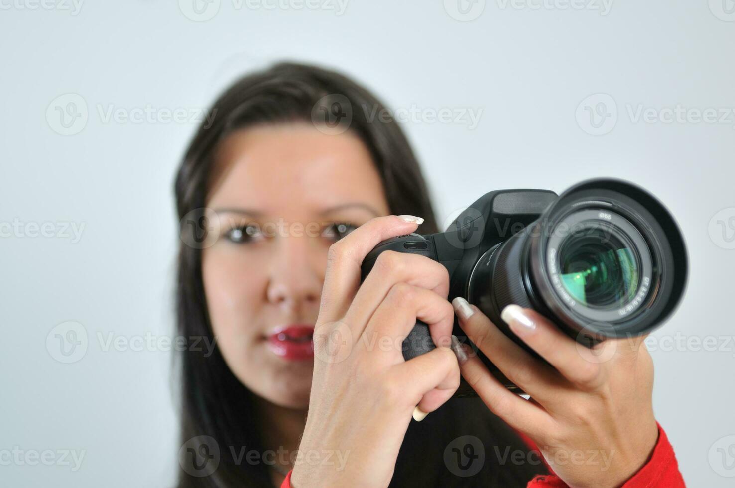 junge frau, die kamera in der hand hält, die bild lokalisiert macht foto