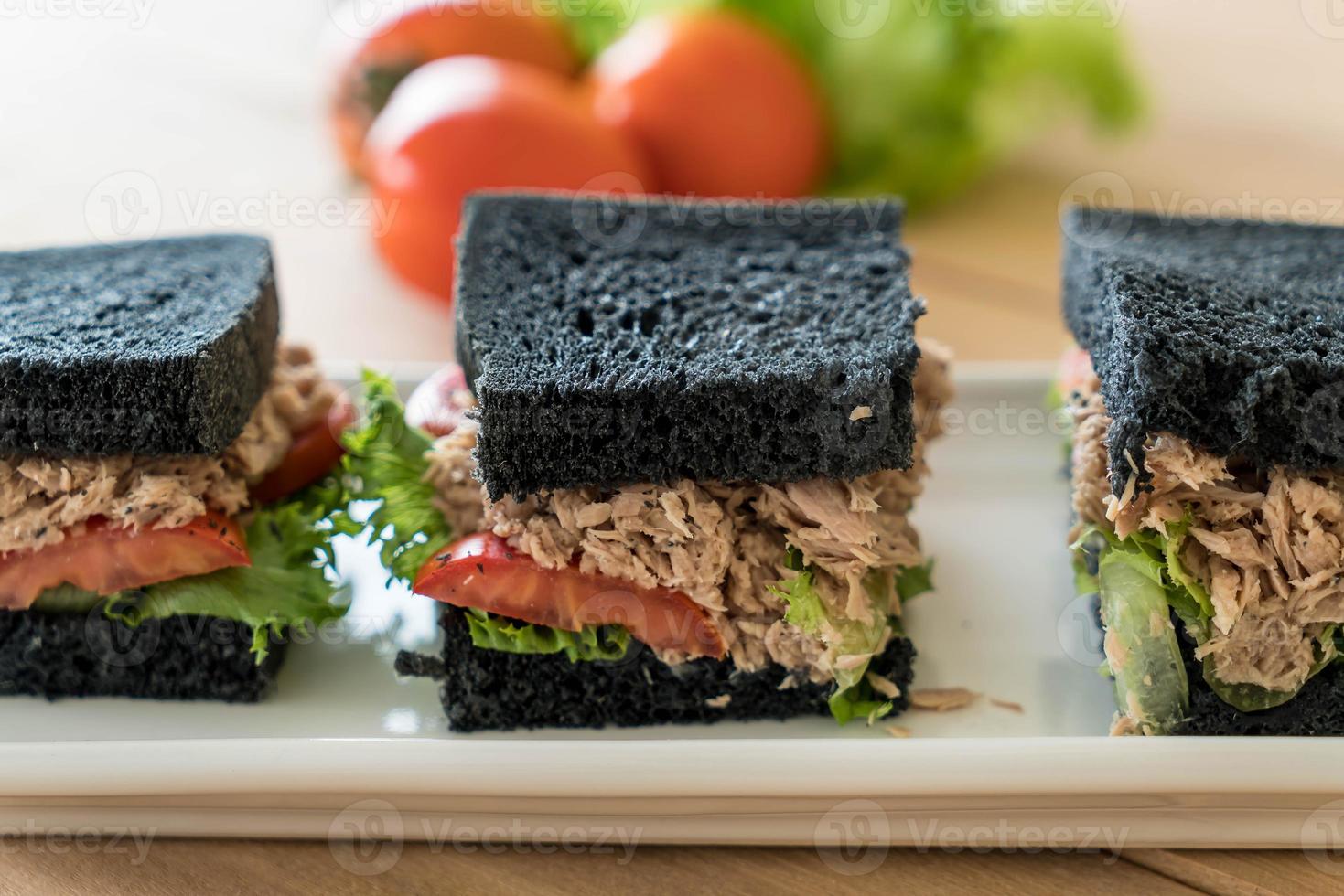 Thunfisch-Holzkohle-Sandwich auf Holztisch foto