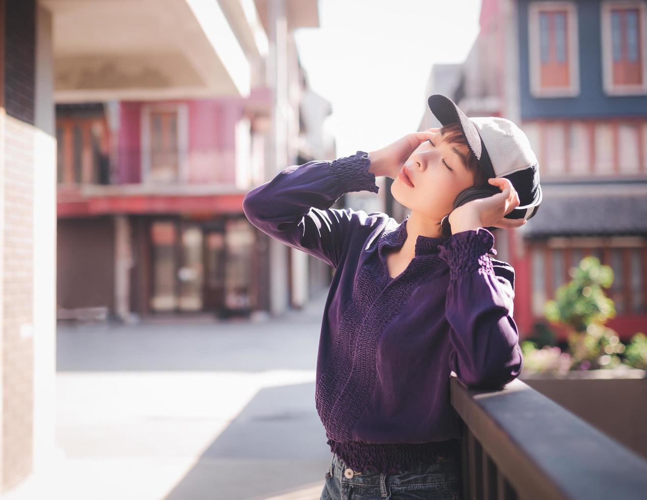 glückliche junge asiatische frau, die musik mit kopfhörern hört foto