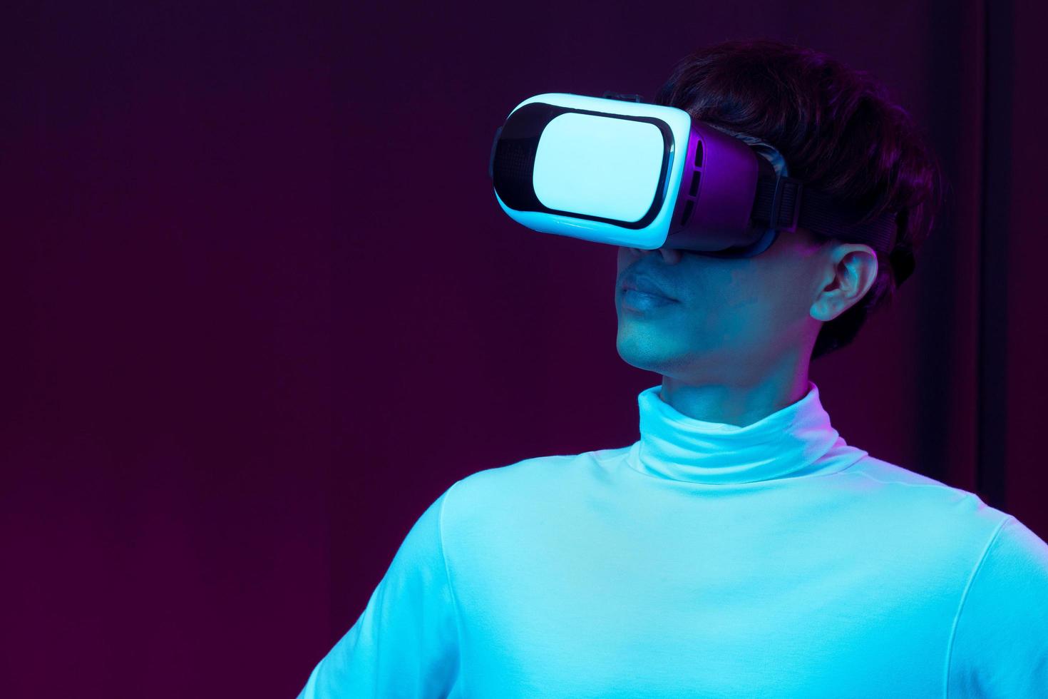 junger asiatischer Mann mit Virtual-Reality-Brille, der 360-Grad-Vdo anschaut foto