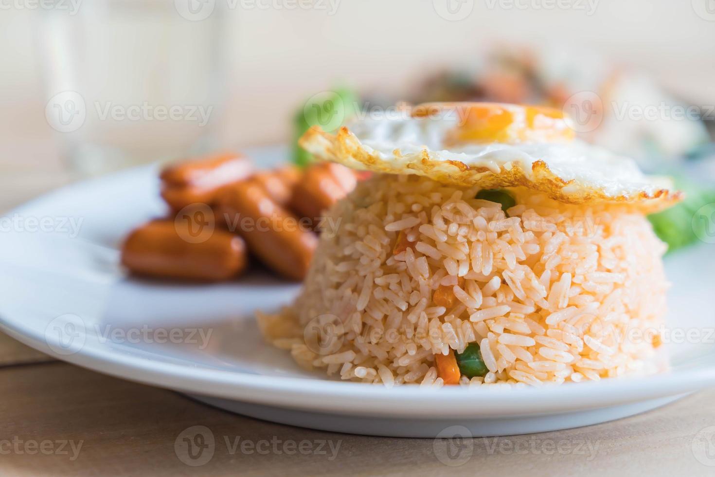 gebratener Reis mit Wurst und Spiegelei auf dem Tisch foto
