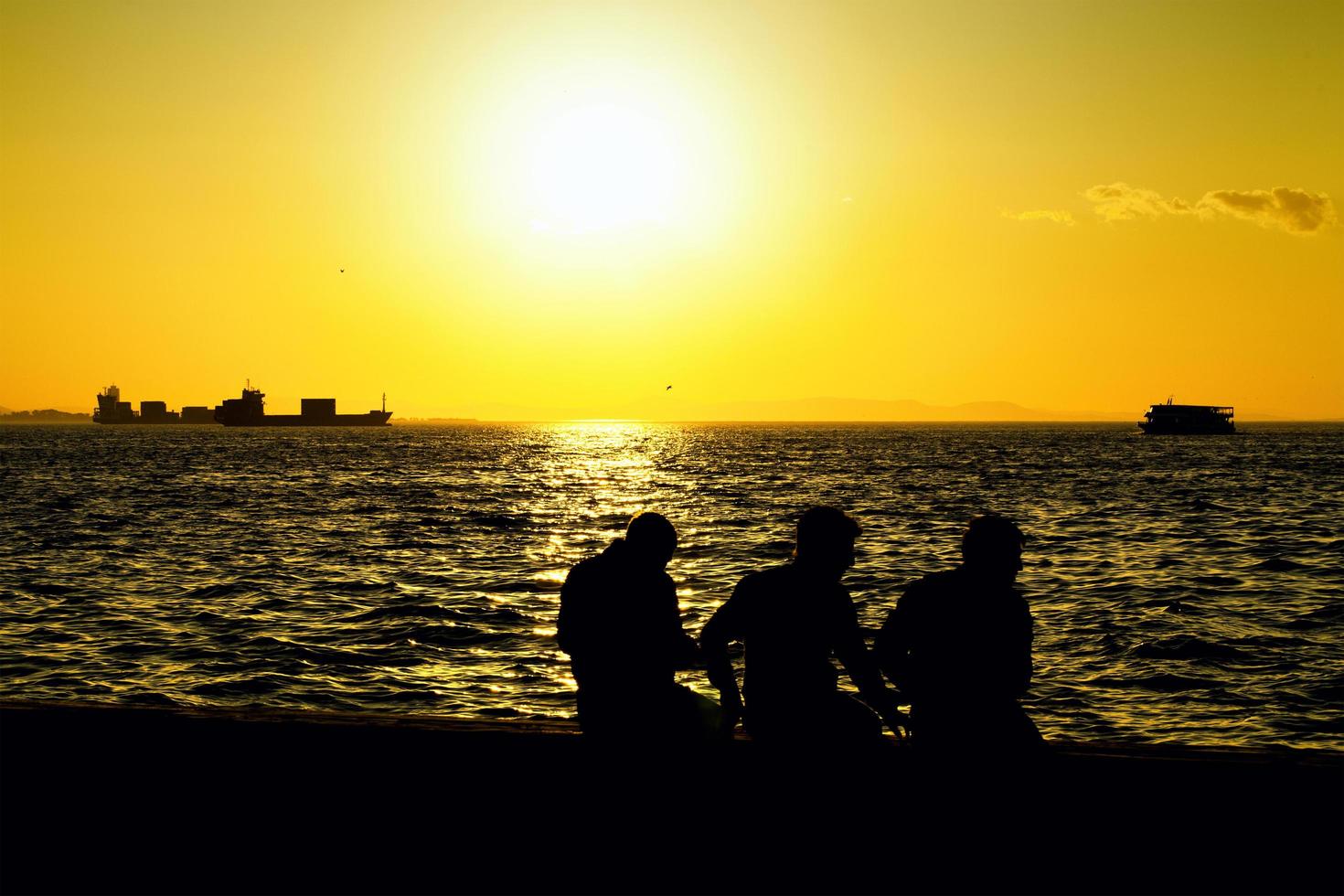 Menschensilhouette und das Meer im Sonnenuntergang foto