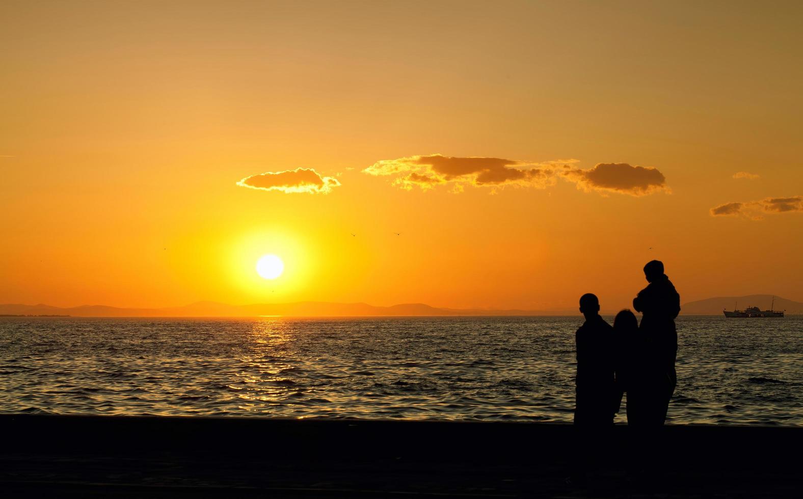 Menschensilhouette und das Meer im Sonnenuntergang foto