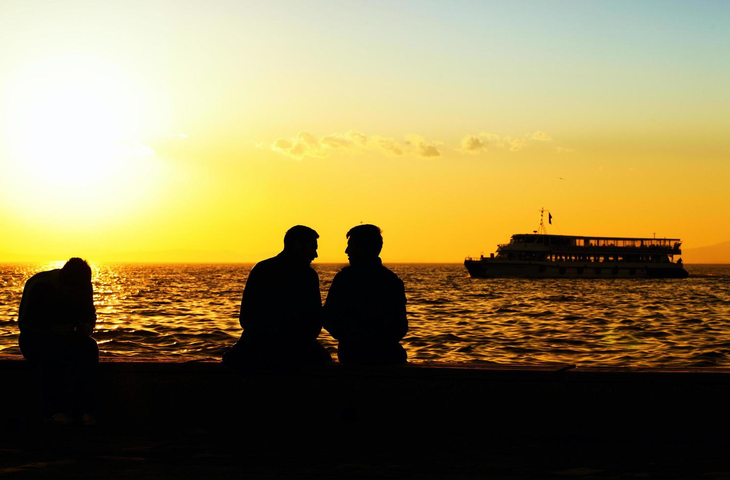 Menschensilhouette und das Meer im Sonnenuntergang foto