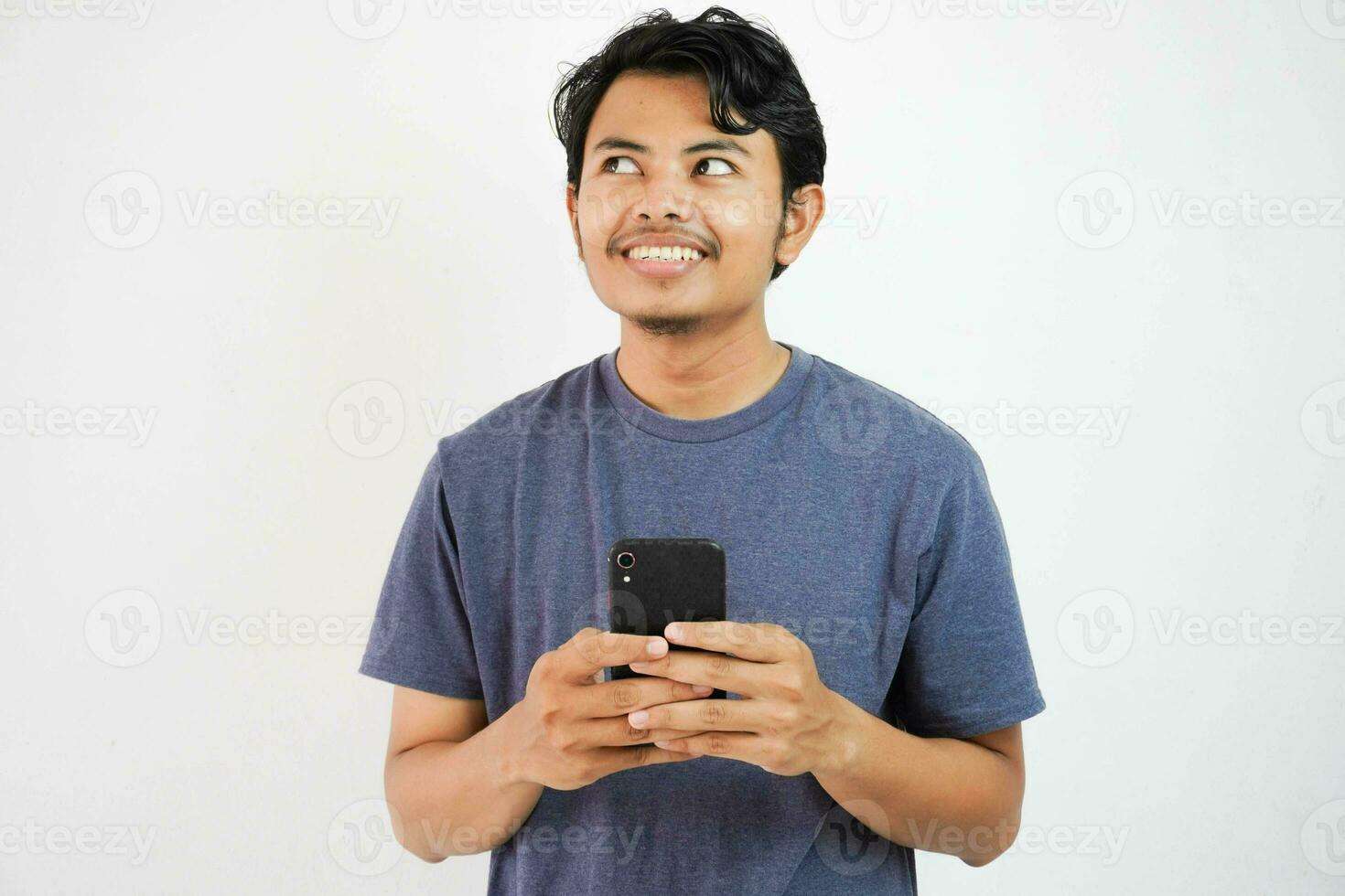 jung asiatisch Mann Träumer Sehen Traum leeren Raum Denken Buchung Botschaft halten Telefon isoliert auf Weiß Hintergrund foto