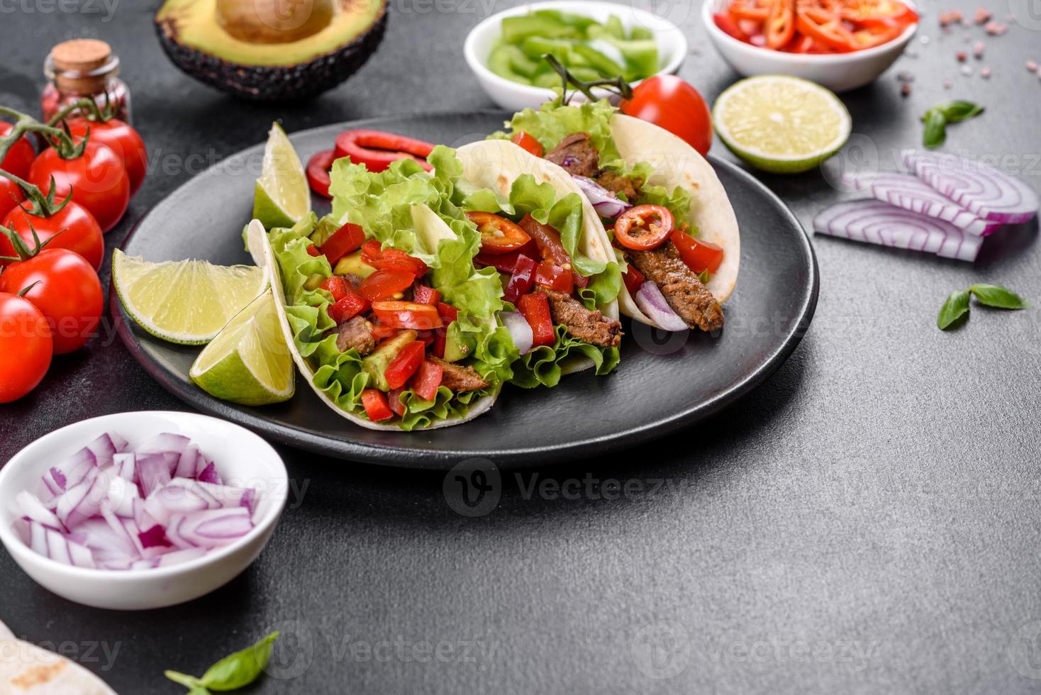 mexikanische Tacos mit Rindfleisch, Tomaten, Avocado, Zwiebeln und Salsasauce foto