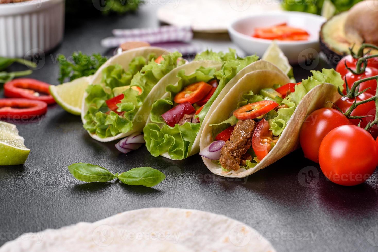 mexikanische Tacos mit Rindfleisch, Tomaten, Avocado, Zwiebeln und Salsasauce foto