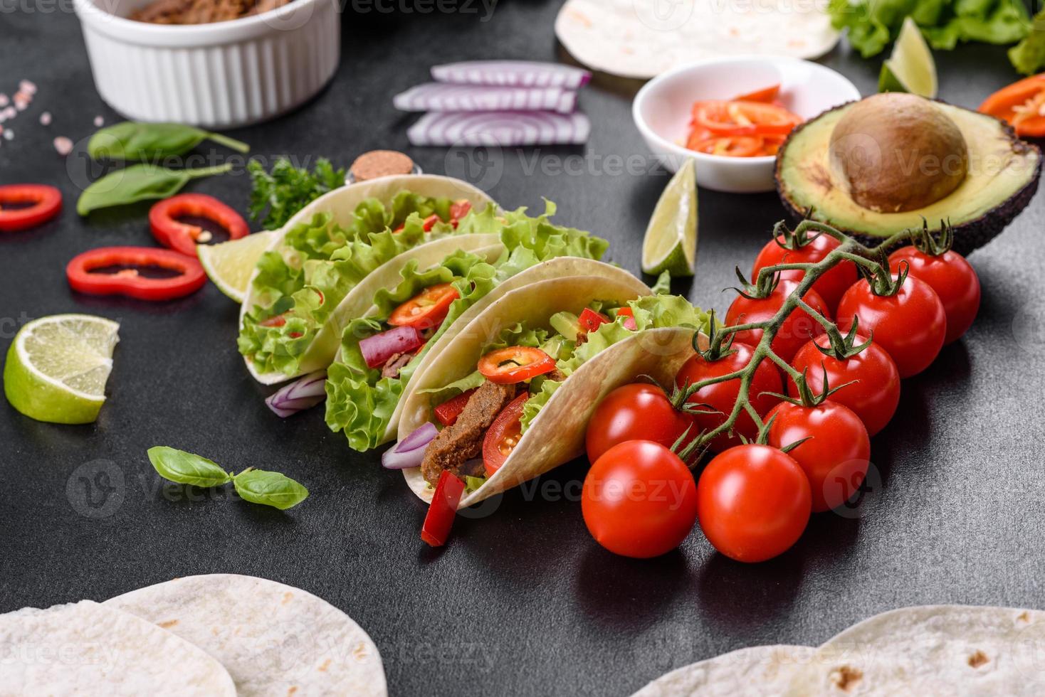 mexikanische Tacos mit Rindfleisch, Tomaten, Avocado, Zwiebeln und Salsasauce foto