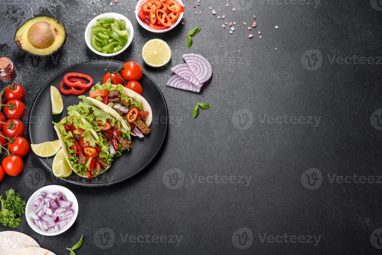 mexikanische Tacos mit Rindfleisch, Tomaten, Avocado, Zwiebeln und Salsasauce foto