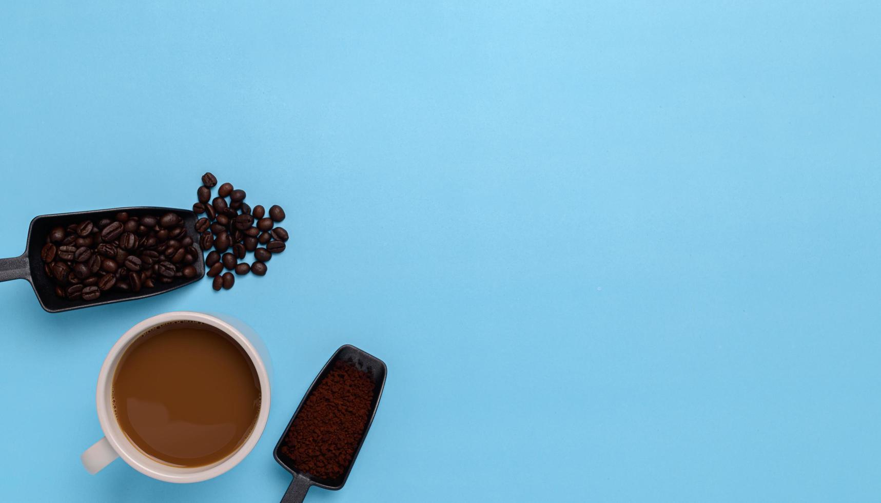 Kaffeetasse, Kaffeebohnen, gemahlener Kaffee auf blauem Grund foto