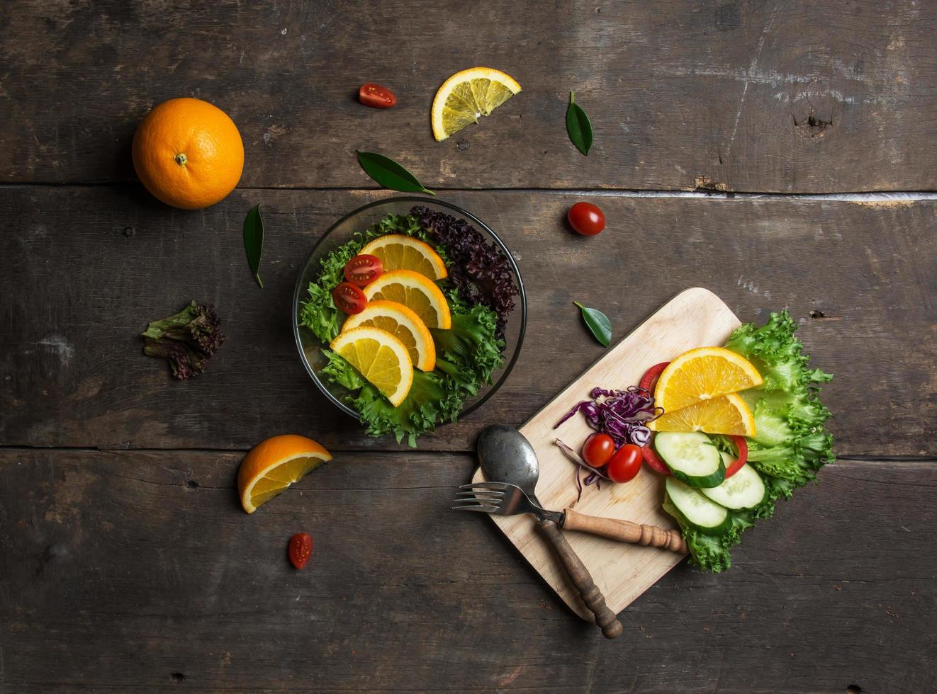 frischer Salat mit Orangenscheibe auf Holzuntergrund foto