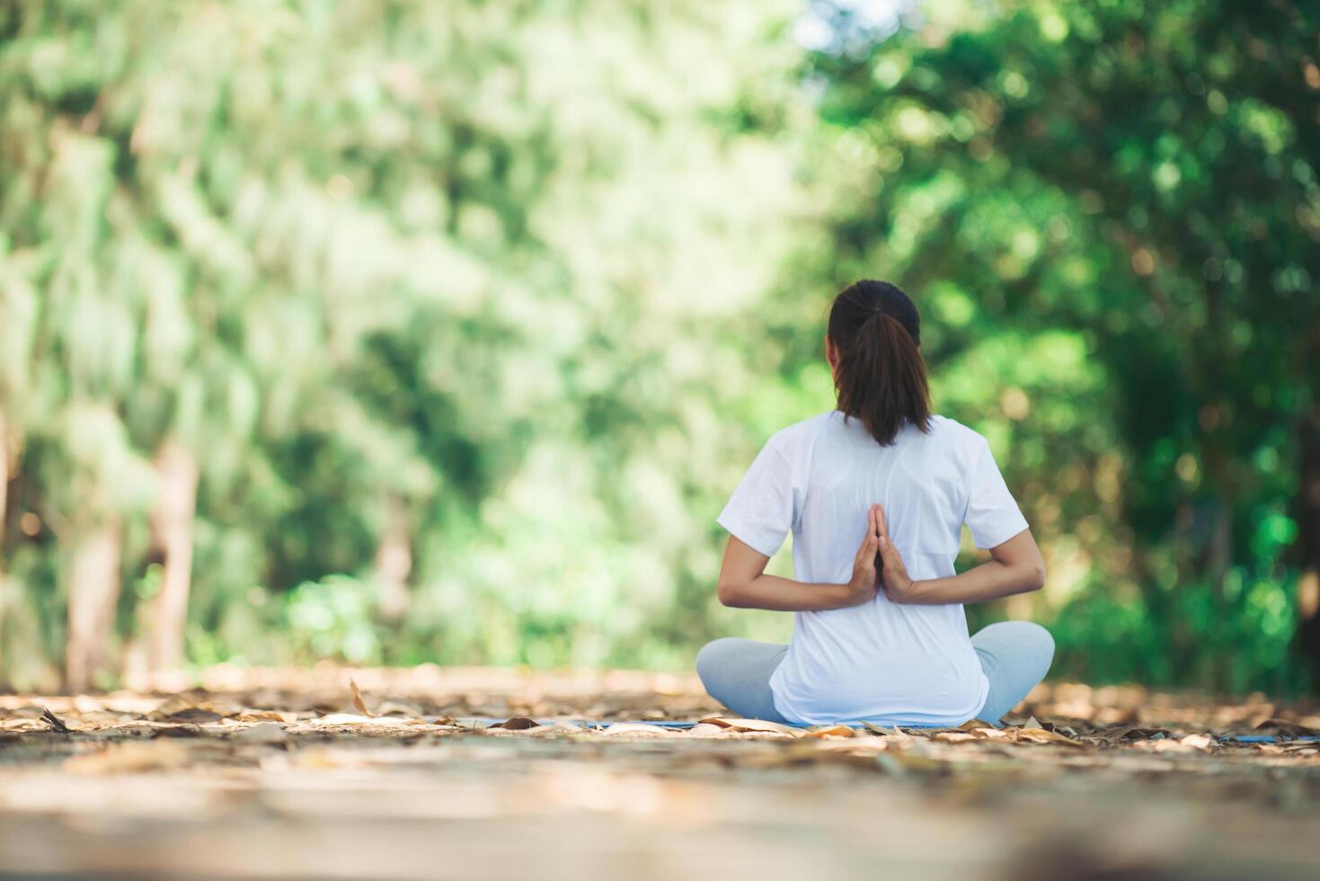 junge asiatische frau, die morgens yoga im park macht. foto