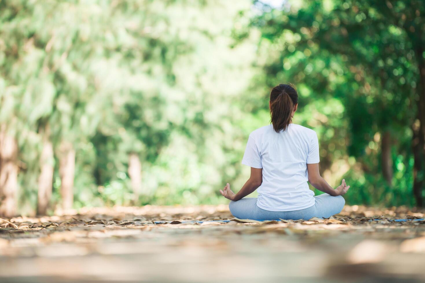 junge asiatische frau, die morgens yoga im park macht. foto