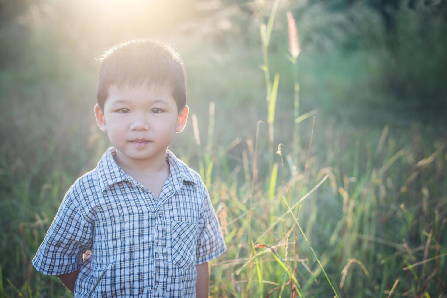 glücklicher kleiner asiatischer Junge, der draußen spielt. süßer Asiate. Junge auf dem Feld. foto