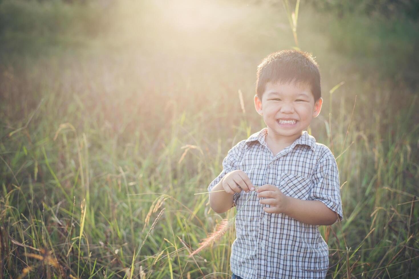 glücklicher kleiner asiatischer Junge, der draußen spielt. süßer Asiate. Junge auf dem Feld. foto