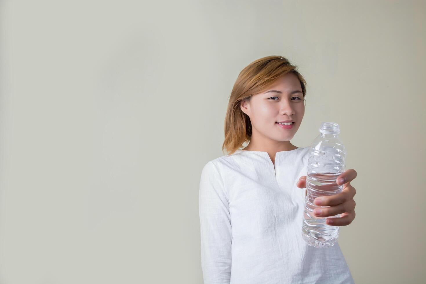 junge Frau, die Wasser trinkt, sieht so frisch aus foto