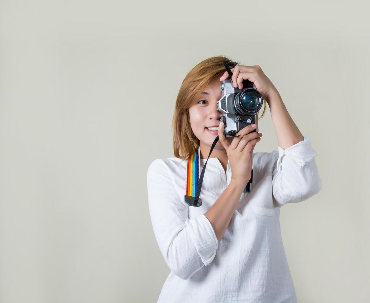 schöne junge Frau Fotografin hält Retro-Kamera foto