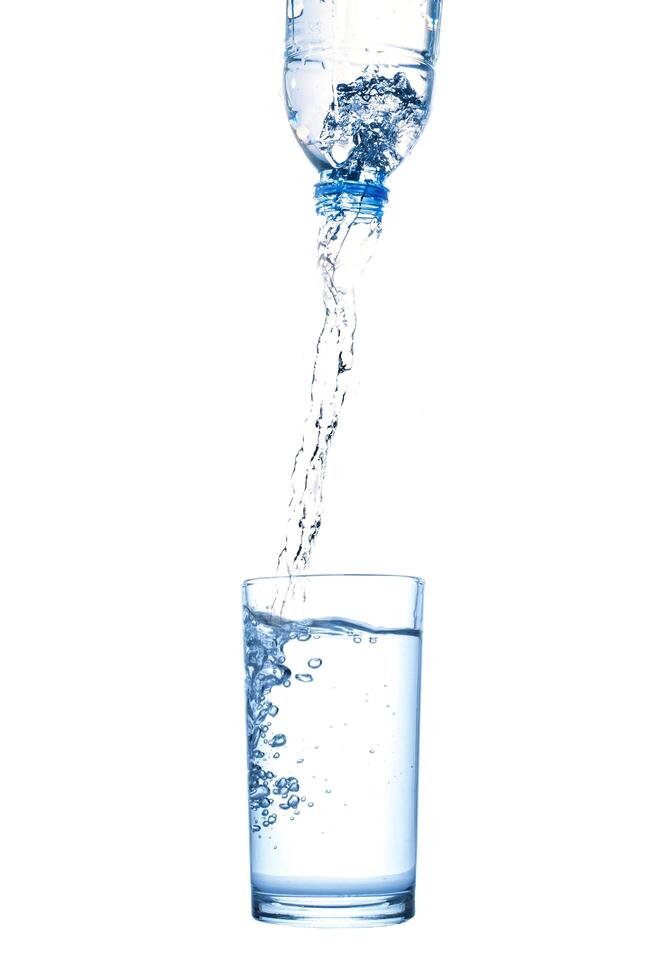 Wasser aus der Flasche in Glas gießen foto