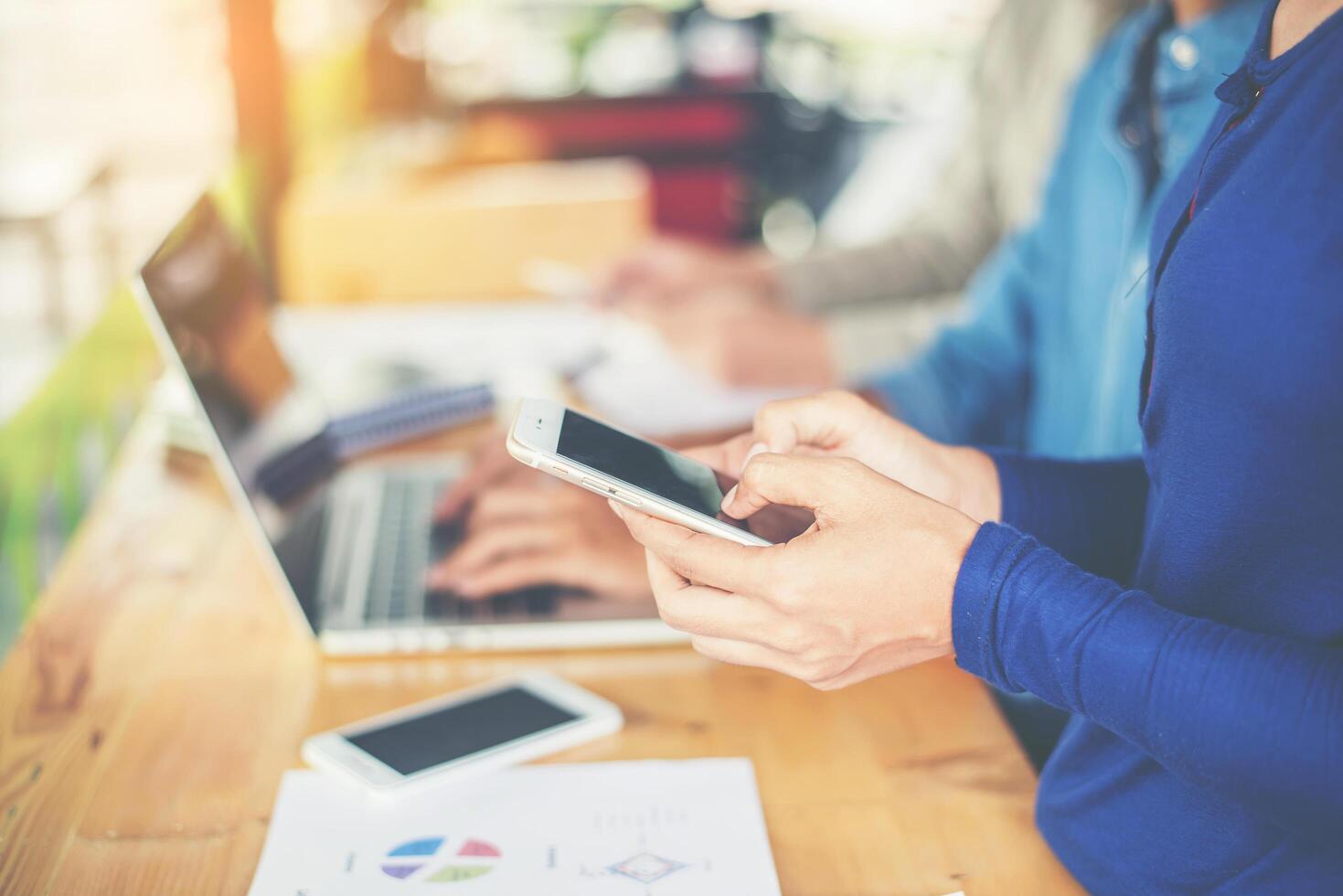 Geschäftsfrauenhand, die am Smartphone mit Geschäftsdiagramm arbeitet. foto