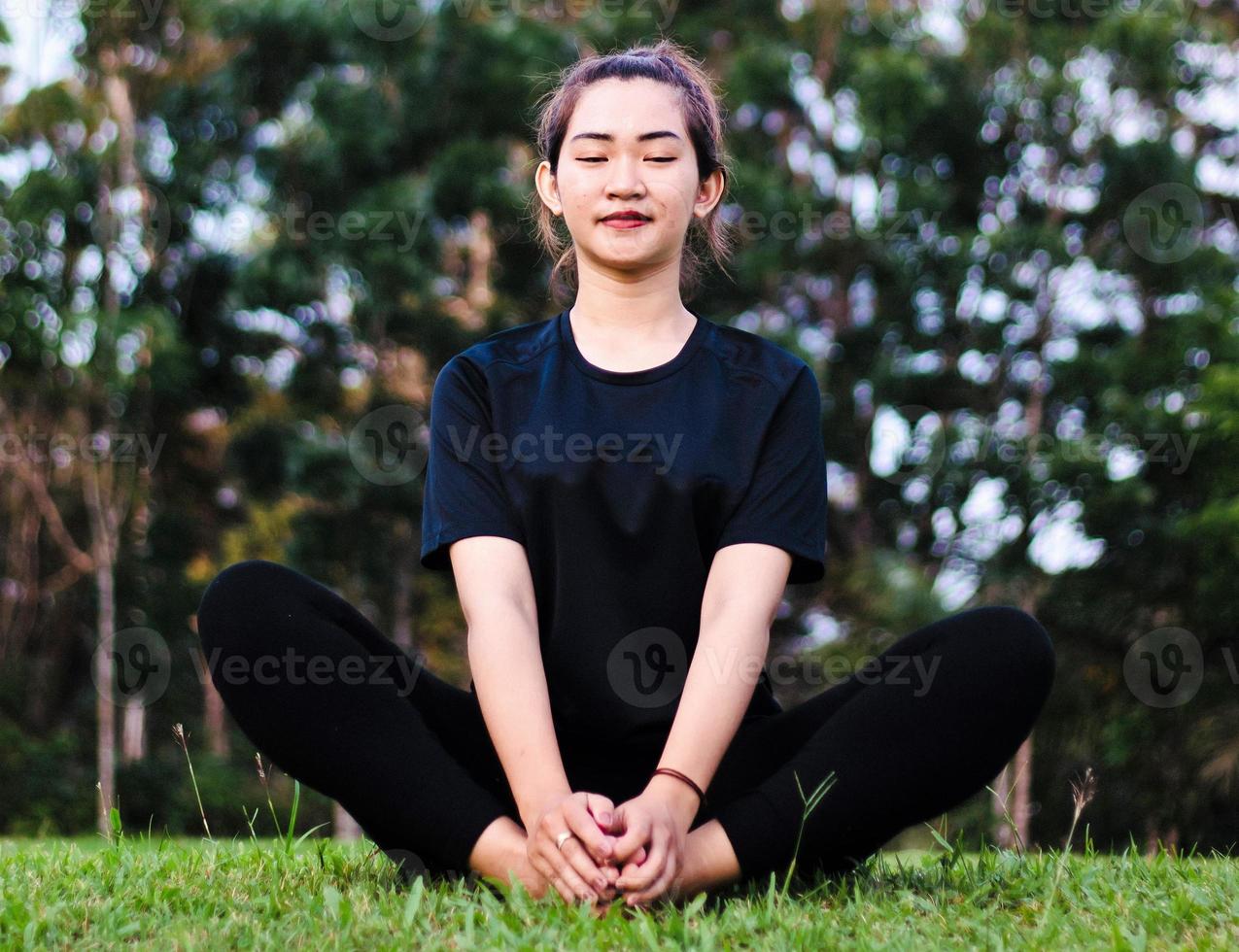 Frau meditiert und praktiziert Yoga im Wald foto