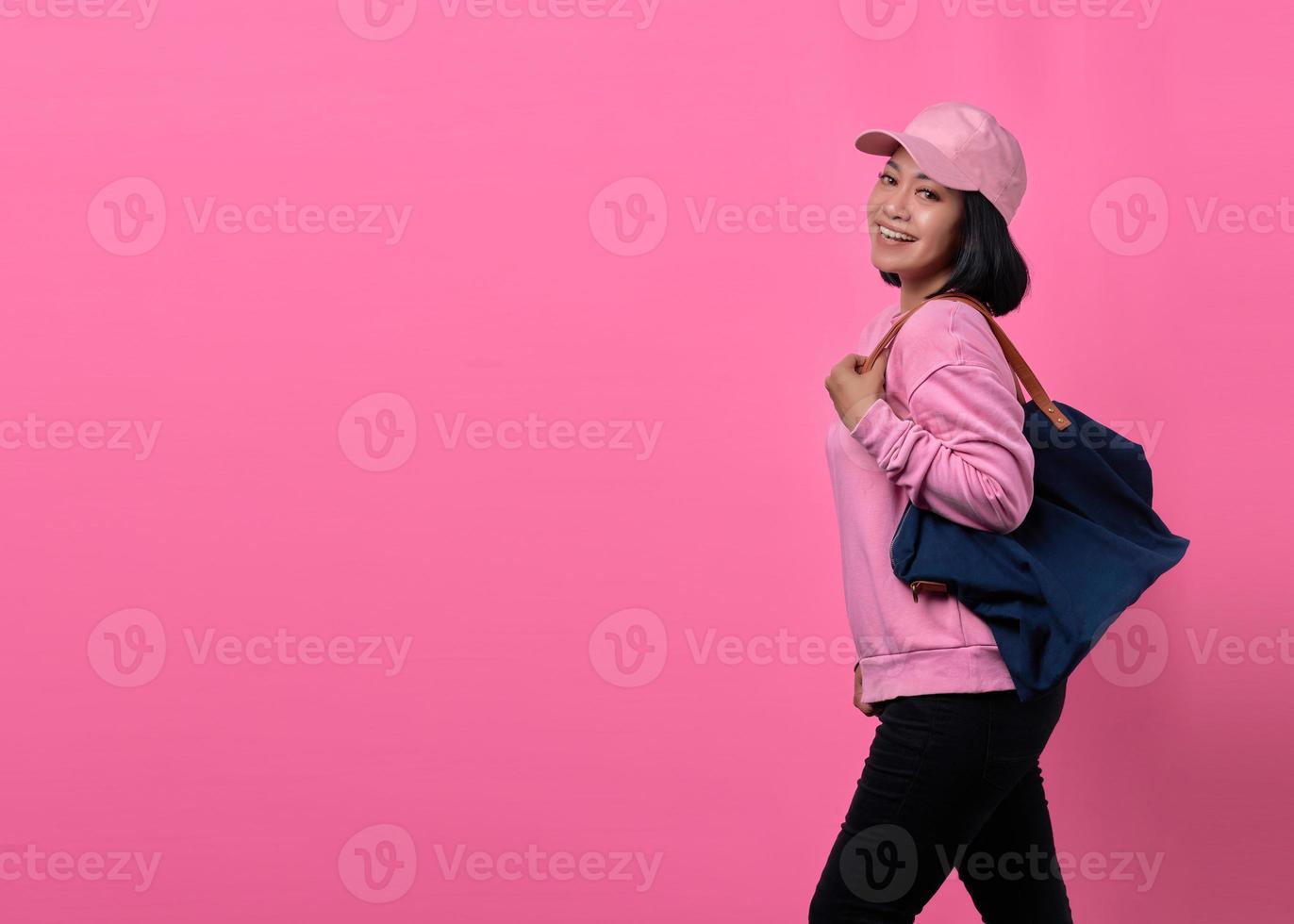 Porträt einer glücklichen jungen Asiatin mit Tasche beim Einkaufen foto