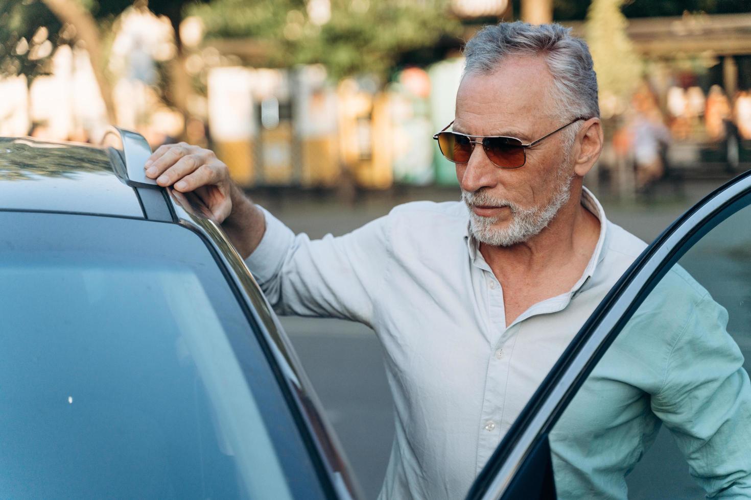 Geschäftsmann Senior Mann steigt nach einem harten Arbeitstag in sein Auto foto