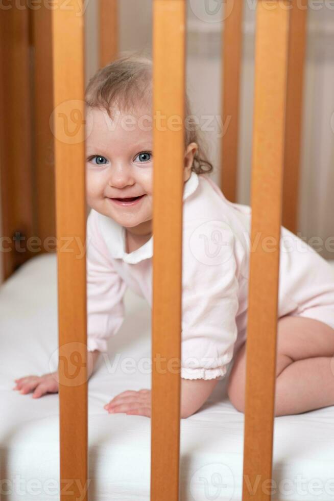 Porträt von ein Lachen wenig Mädchen Wer ist im ein Krippe foto