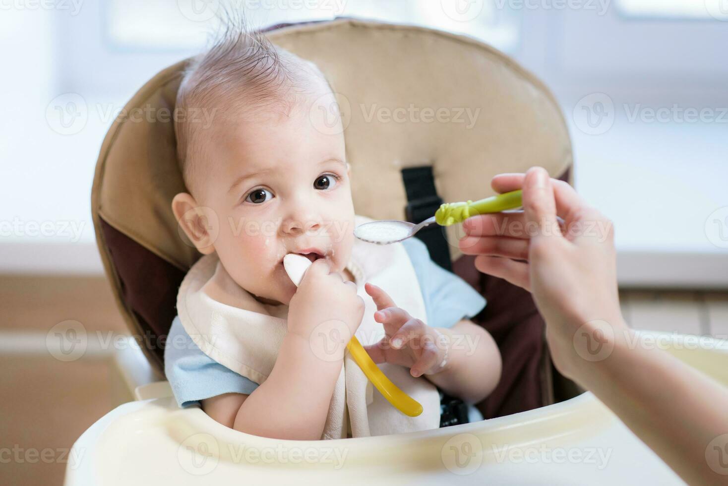 Mutter gibt Baby Essen von ein Löffel foto