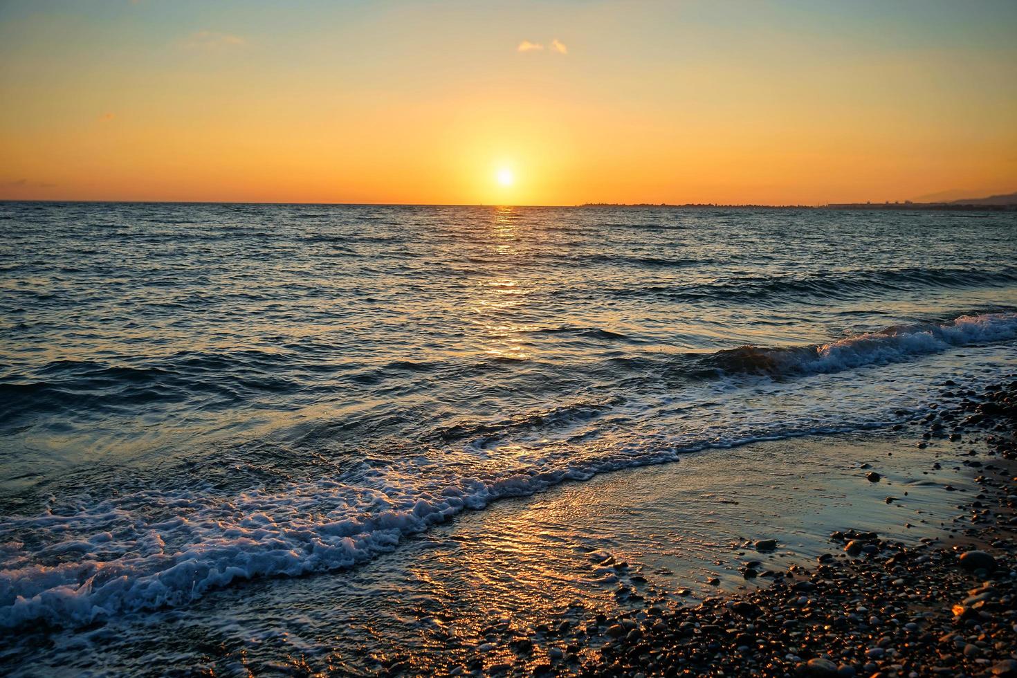 Seelandschaft mit einem wunderschönen Sonnenuntergang im Hintergrund des Meeres foto