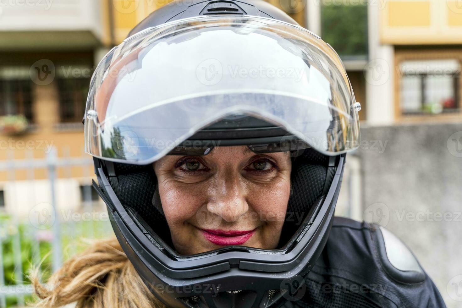 Porträt von reifen Frau mit Motorrad Helm draußen foto