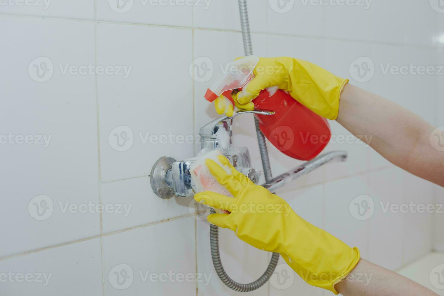 Hausfrau Reinigung Badezimmer Zapfhahn und Dusche klopfen. Maid im Gelb schützend Handschuhe Waschen schmutzig Bad klopfen. Hände von Frau Waschen Bad foto