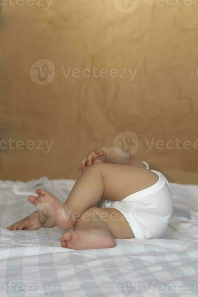 6-8 Monate alt Baby Junge Lügen spielerisch im Bett. charmant 6-7 Monat wenig Baby im Weiß Body. Baby Junge im Weiß Bettwäsche. Kopieren Raum foto