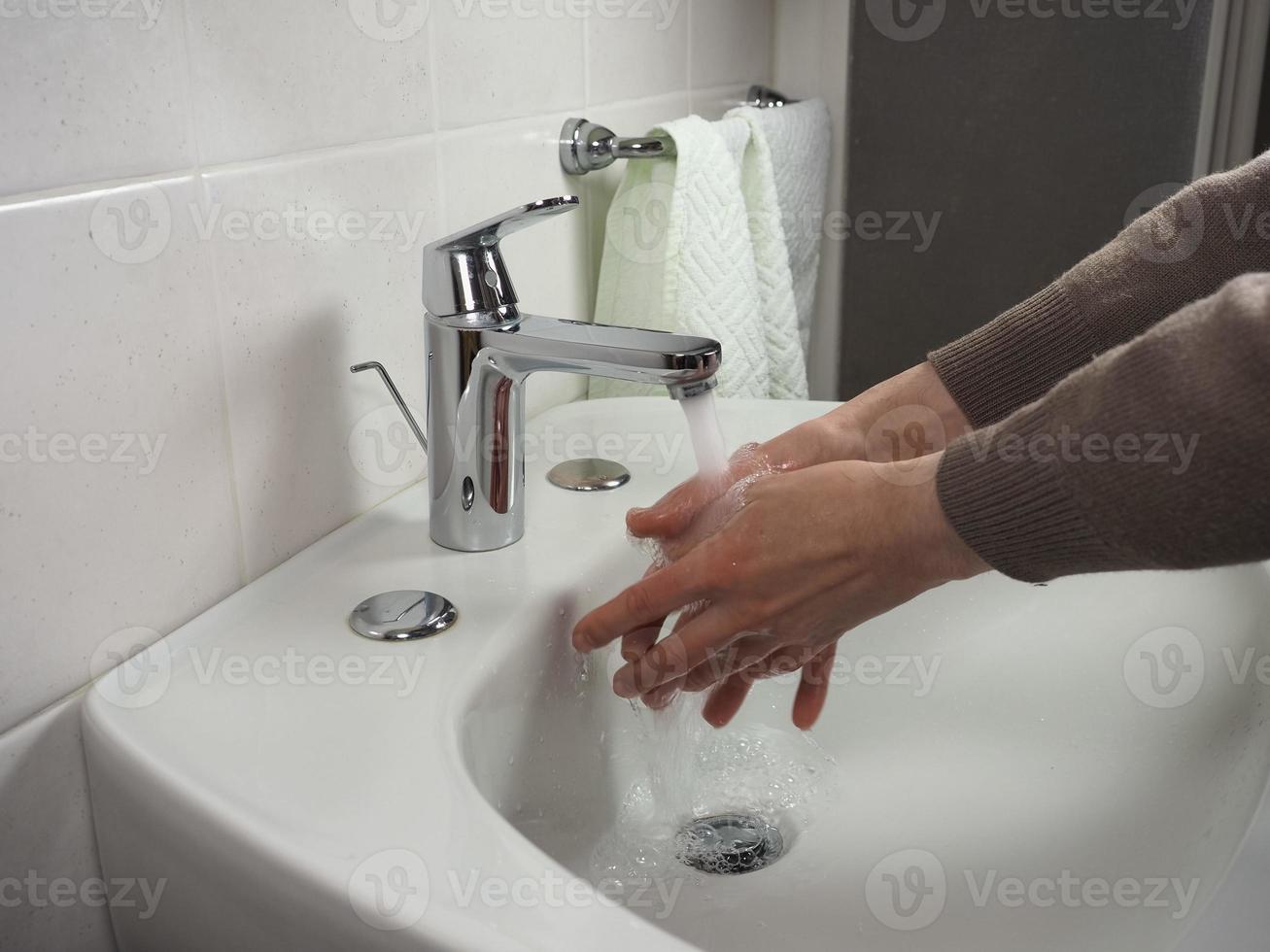 Unerkennbarer Mann beim Händewaschen foto
