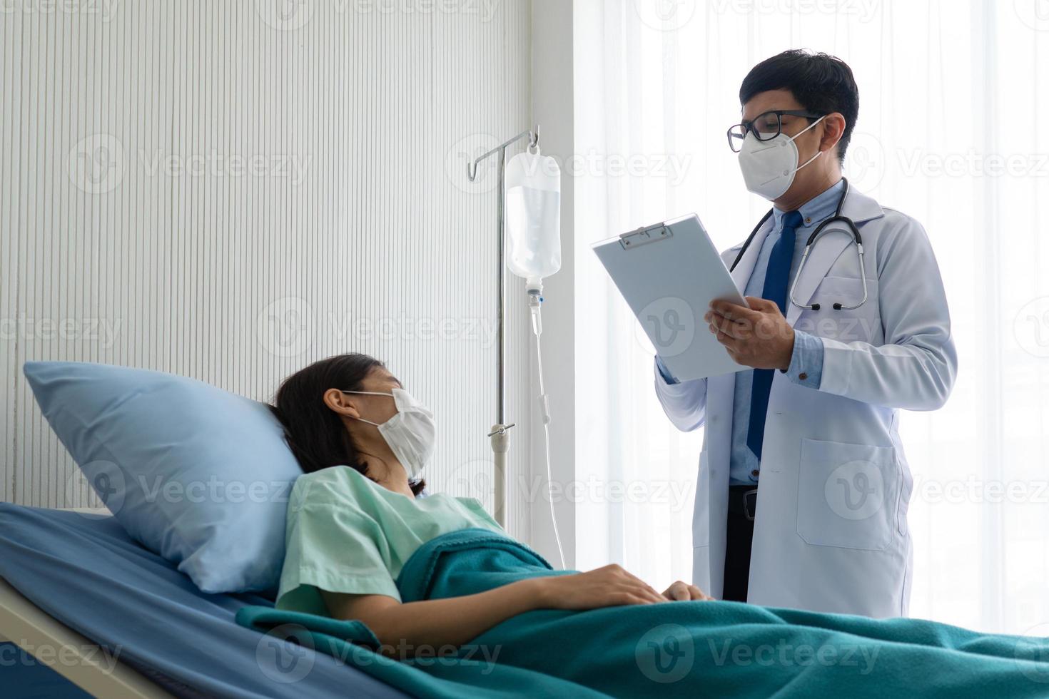 asiatischer Arzt besucht Patienten in der Krankenstation foto