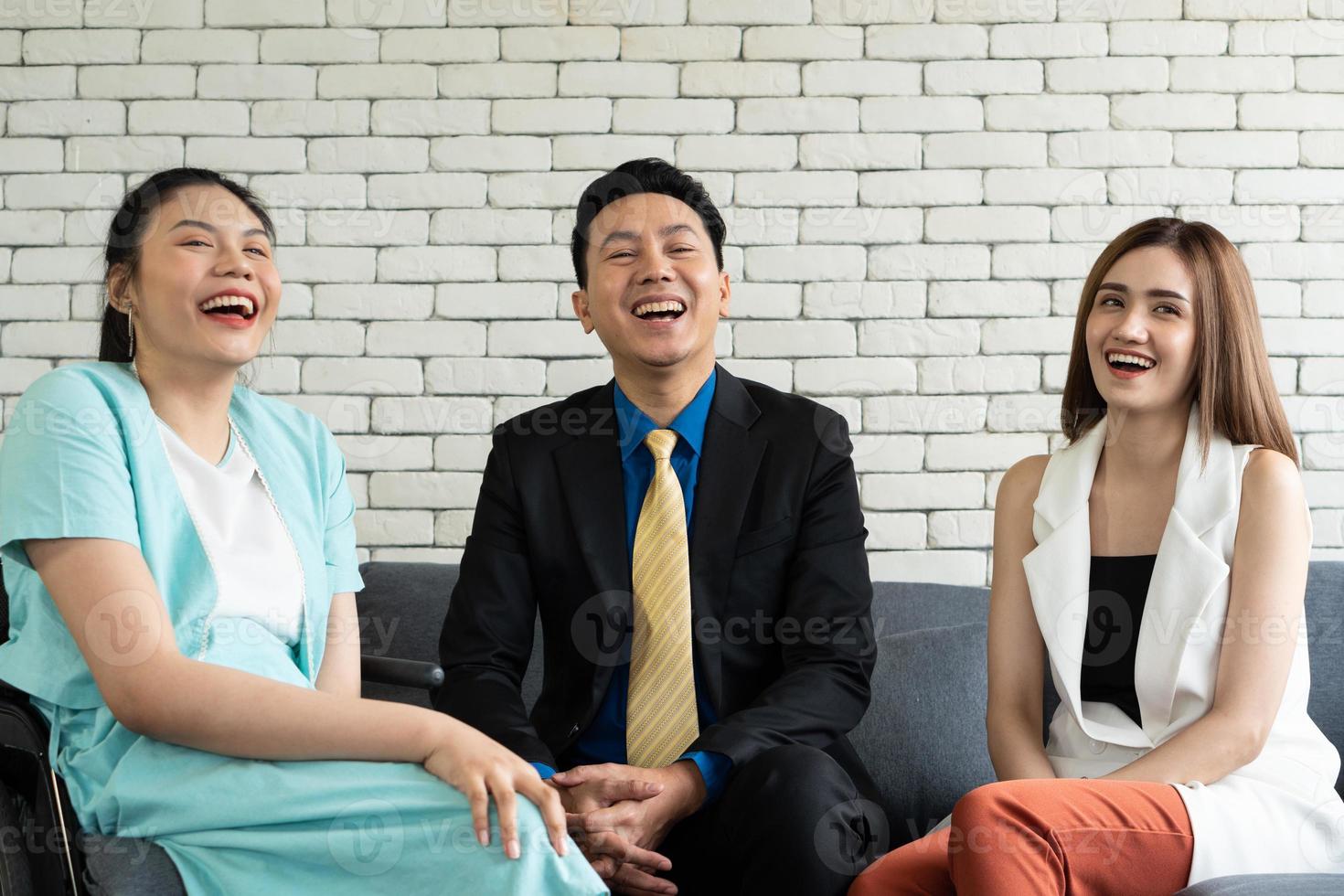 asiatische behinderte frau, die mit kollegen im büro lacht foto