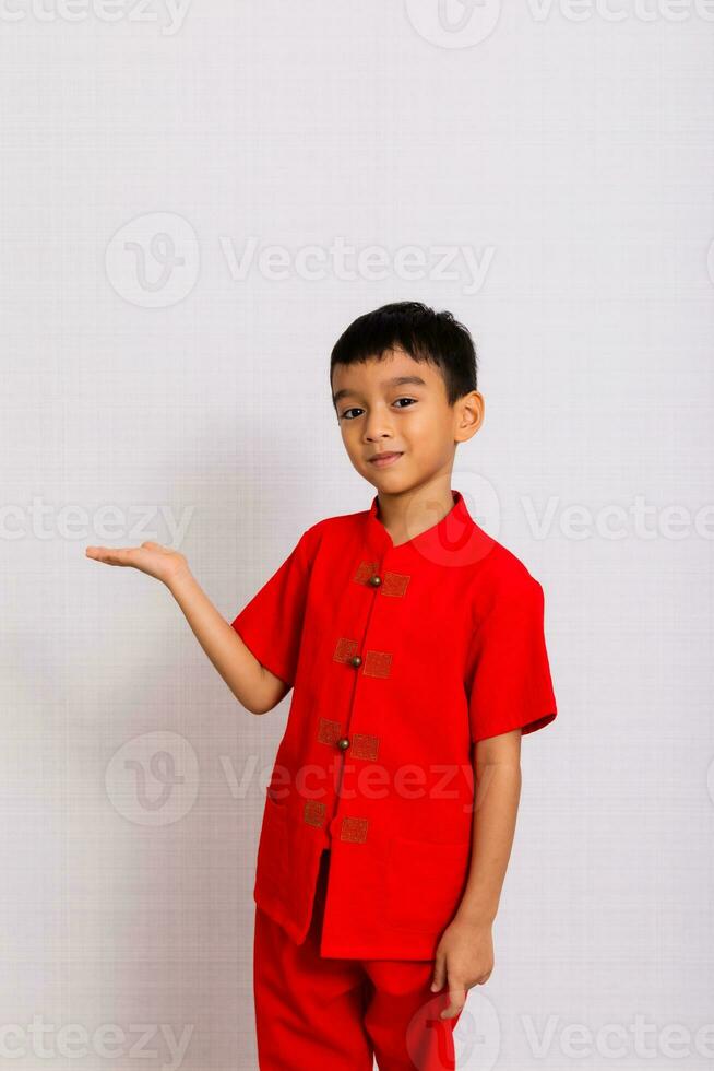 wenig Junge Mode lächelnd Kind einladend im rot Chinesisch Kleid Stile und Mode Ideen zum Kinder Chinesisch Neu Jahr, Chinesisch Neu Jahr foto