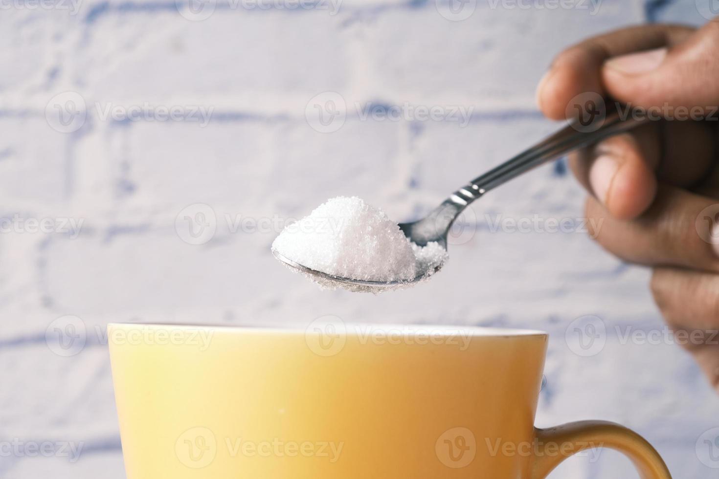 Weißzucker in eine Teetasse gießen foto