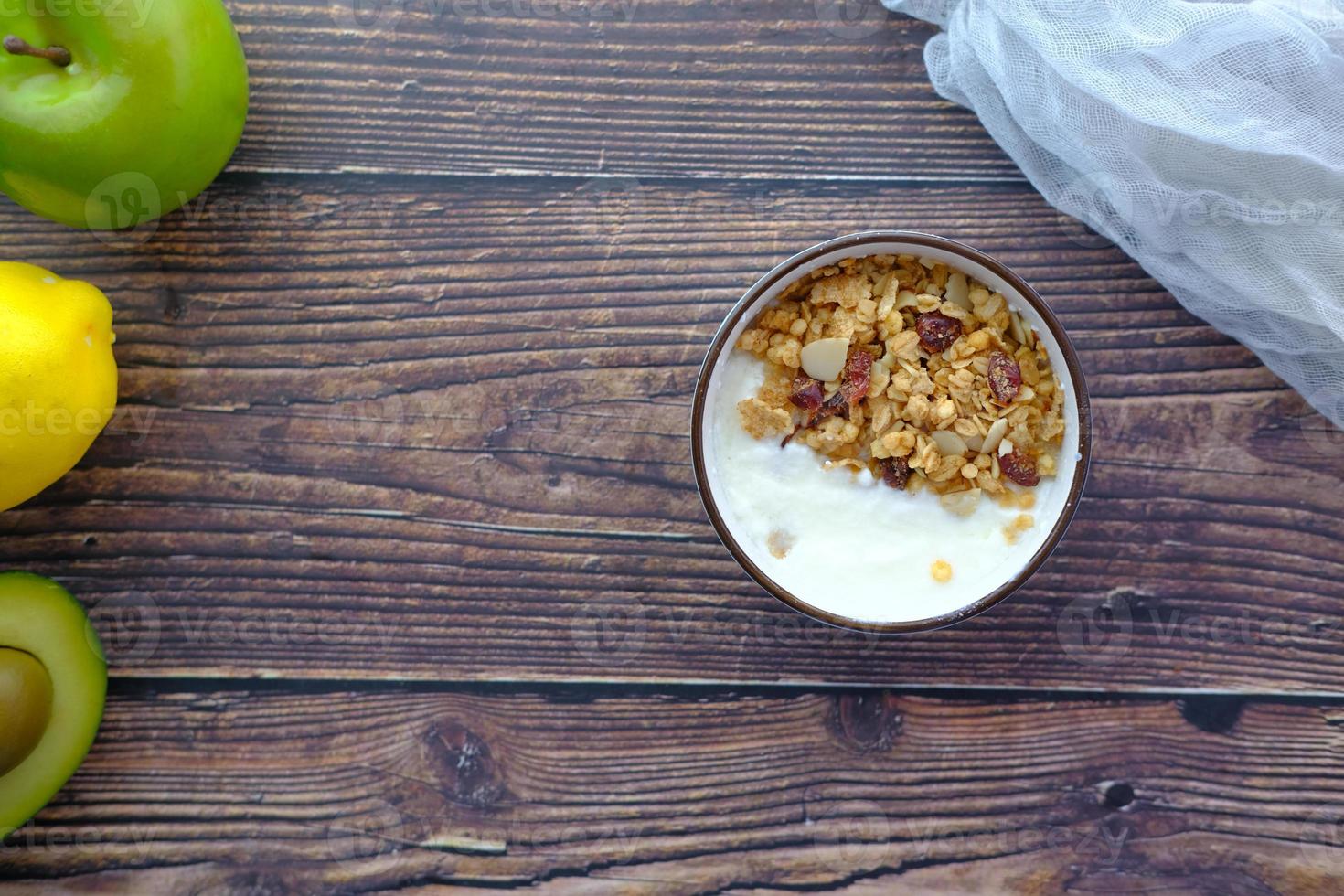 Joghurt-Müsli-Frühstück in Schüssel auf Holzuntergrund foto