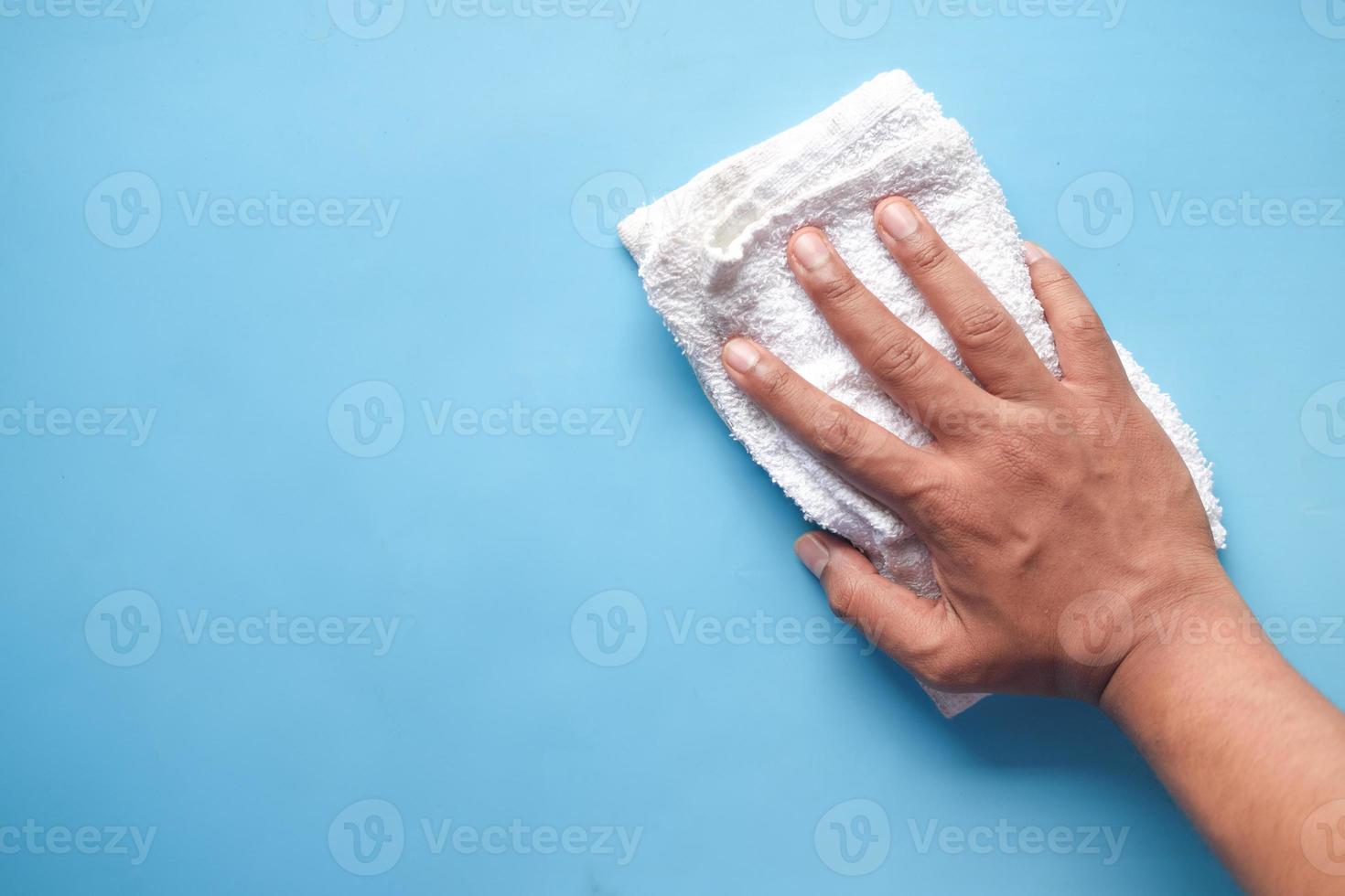 Mannhand, die flache Oberfläche mit Tuch säubert foto