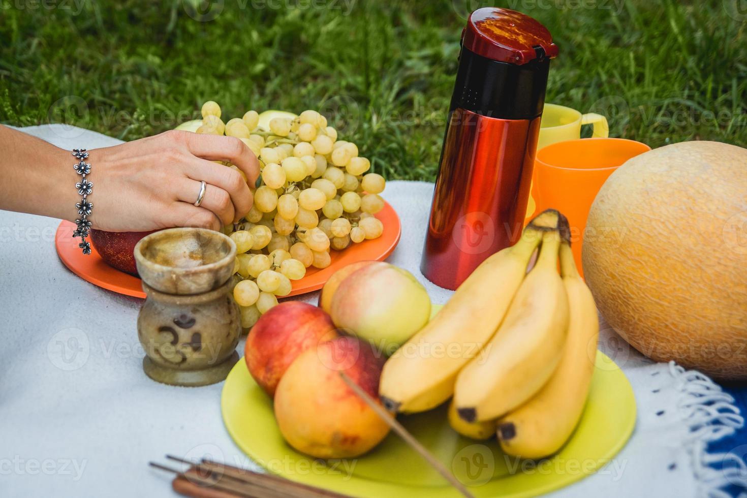 Picknickhintergrund mit Weißwein und Sommerfrüchten auf grünem Gras foto